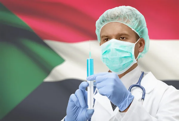 Médecin avec une seringue dans les mains et le drapeau sur la série de fond - Soudan — Photo