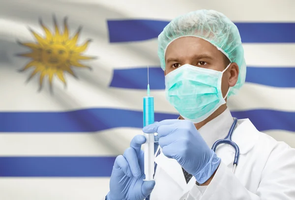 Médecin avec une seringue dans les mains et le drapeau sur la série de fond - Uruguay — Photo