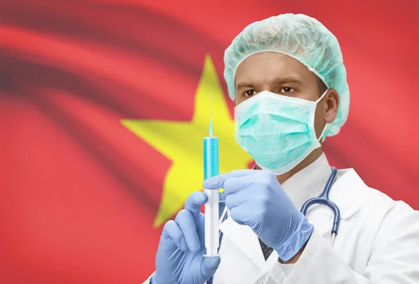 Lekarz z strzykawka w ręce i flagi na tle serii - Wietnam — Zdjęcie stockowe