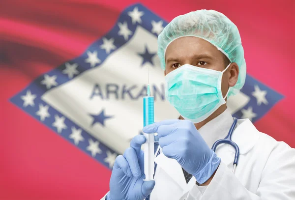 Docteur avec une seringue dans les mains et nous indique les drapeaux sur les séries de fond - Arkansas — Photo