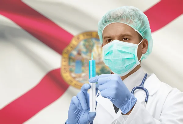 Doctor with syringe in hands and US states flags on background series - Florida — Foto Stock