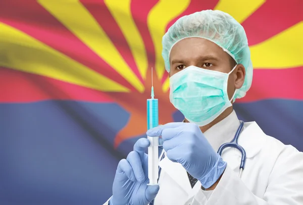 Docteur avec une seringue dans les mains et nous indique les drapeaux sur les séries de fond - Arizona — Photo