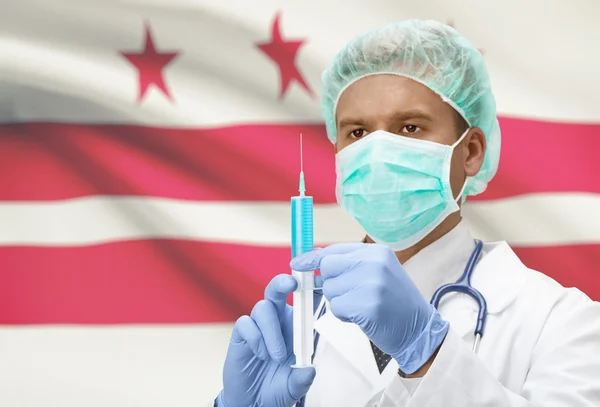 Doctor with syringe in hands and US states flags on background series - District of Columbia — Stok fotoğraf