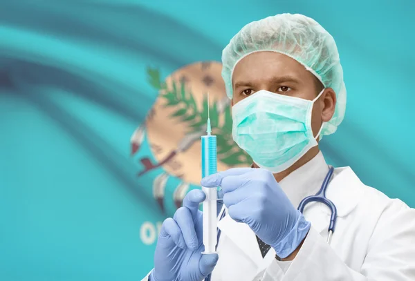 Doctor with syringe in hands and US states flags on background series - Oklahoma — Foto de Stock