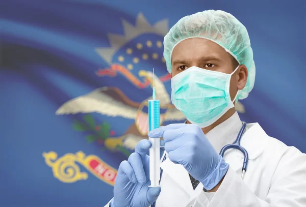 Doctor with syringe in hands and US states flags on background series - North Dakota — Zdjęcie stockowe