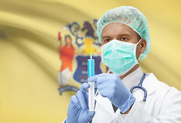 Doctor with syringe in hands and US states flags on background series - New Jersey — Stockfoto