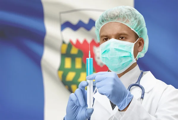 Médecin avec une seringue dans les mains et le drapeau de la province canadienne sur série de fond - Territoires du Nord-Ouest — Photo