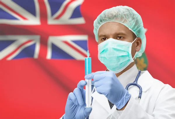 Médico con jeringa en las manos y la bandera de la provincia canadiense en serie de fondo - Ontario — Foto de Stock