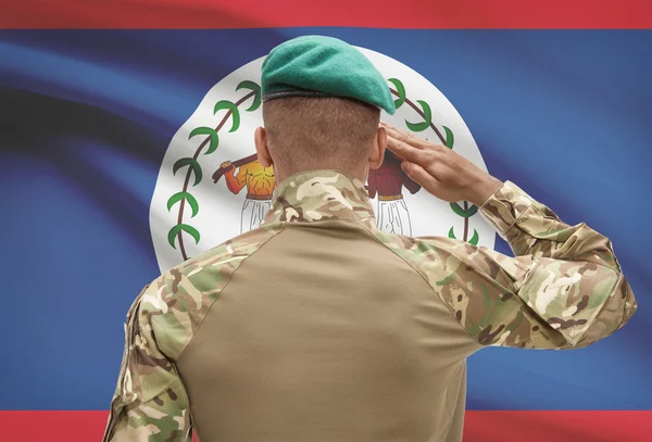 Dark-skinned soldier with flag on background - Belize — Stock Photo, Image
