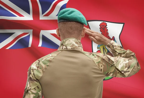 Dark-skinned soldier with flag on background - Bermuda — Stock Photo, Image