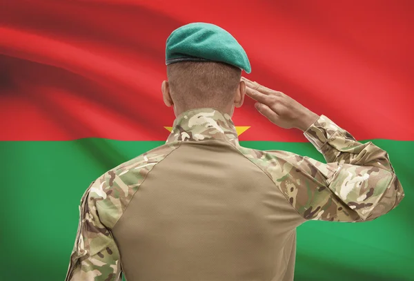 Donkerhuidige soldaat met vlag op achtergrond - Burkina Faso — Stockfoto