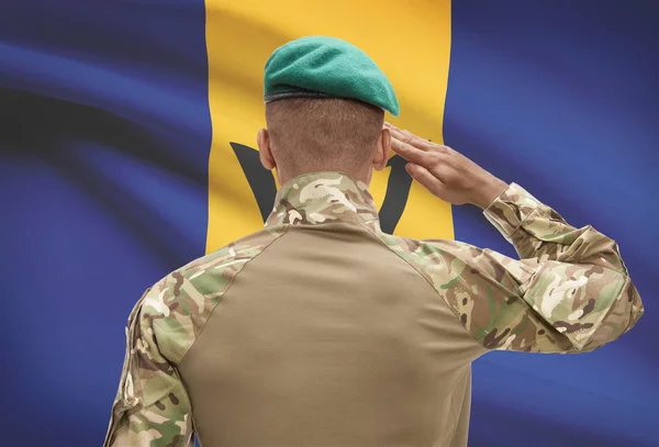 Dark-skinned soldier with flag on background - Barbados — Stock Photo, Image