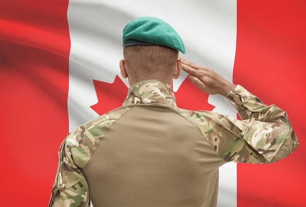 Donkerhuidige soldaat met vlag op achtergrond - Canada — Stockfoto