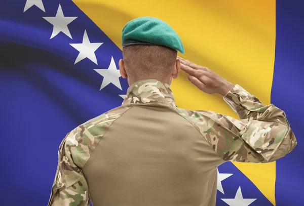 Dark-skinned soldier with flag on background - Bosnia and Herzegovina — Stock Photo, Image