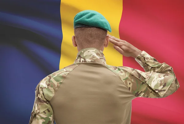 Dark-skinned soldier with flag on background - Chad — Stock Photo, Image