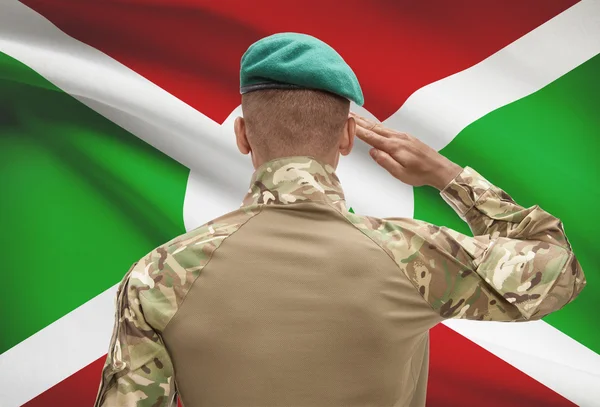 Dark-skinned soldier with flag on background - Burundi — Stock Photo, Image