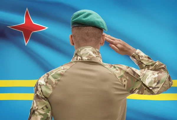 Dark-skinned soldier with flag on background - Aruba — Stock Photo, Image