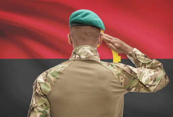 Dark-skinned soldier with flag on background - Angola — Stock Photo, Image