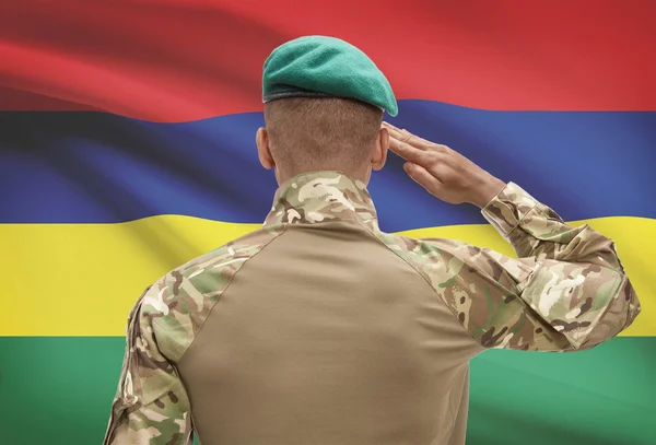 Dark-skinned soldier with flag on background - Mauritius — Stock Photo, Image