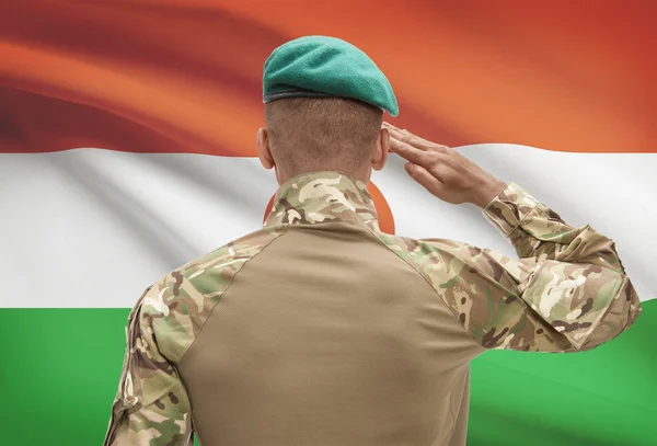 Donkerhuidige soldaat met vlag op achtergrond - Niger — Stockfoto