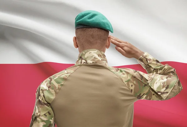 Dark-skinned soldier with flag on background - Poland — Stock Photo, Image