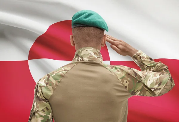 Dark-skinned soldier with flag on background - Greenland — Stock Photo, Image