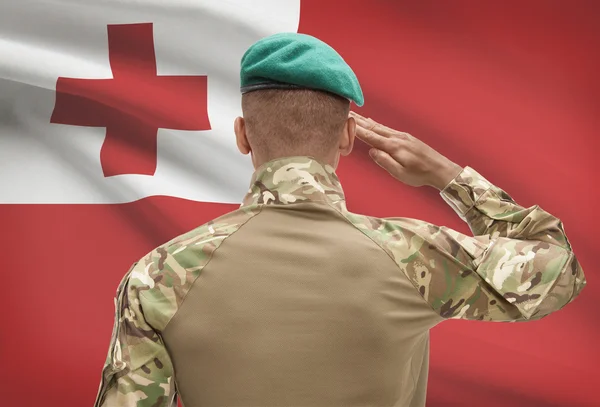 Donkerhuidige soldaat met vlag op achtergrond - Tonga — Stockfoto