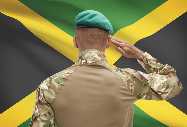 Dark-skinned soldier with flag on background - Jamaica — Stock Photo, Image