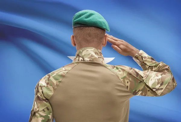 Dark-skinned soldier with flag on background - Somalia — Stock Photo, Image