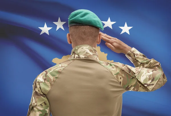 Sötét bőrű katona zászló a háttérben - Koszovó — Stock Fotó