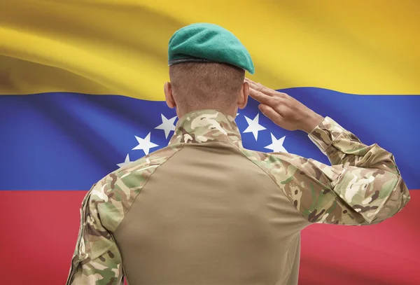 Dark-skinned soldier with flag on background - Venezuela — Stock Photo, Image