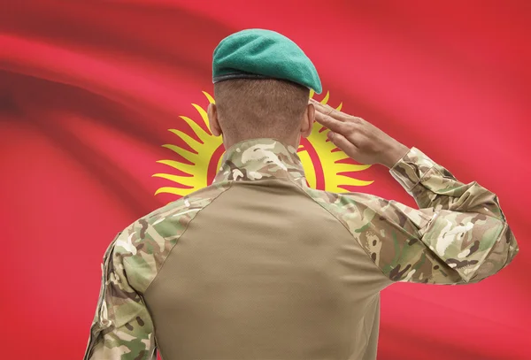 Donkerhuidige soldaat met vlag op achtergrond - Kirgizië — Stockfoto