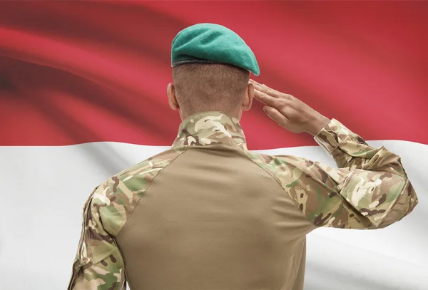 Piel oscura soldado con bandera sobre fondo - Indonesia — Foto de Stock