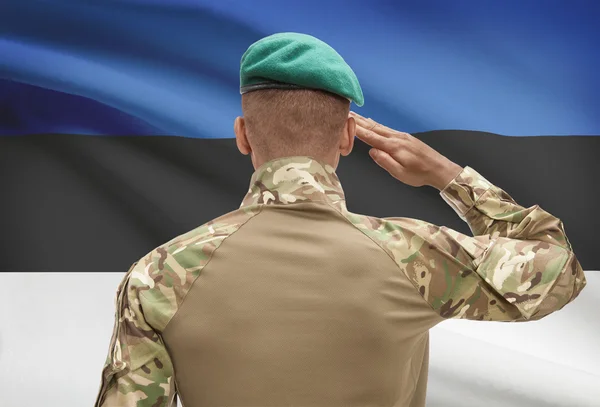 Dark-skinned soldier with flag on background - Estonia — Stock Photo, Image