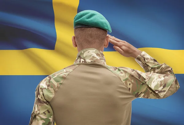 Dark-skinned soldier with flag on background - Sweden — Stock Photo, Image
