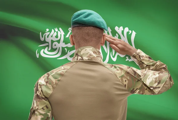 Dark-skinned soldier with flag on background - Saudi Arabia — Stock Photo, Image