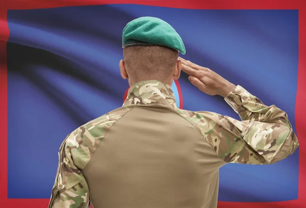 Dark-skinned soldier with flag on background - Guam — Stock Photo, Image