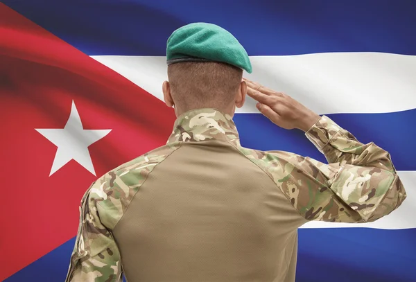Dark-skinned soldier with flag on background - Cuba — Stock Photo, Image