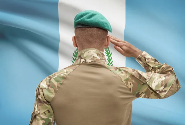 Piel oscura soldado con bandera sobre fondo - Guatemala —  Fotos de Stock