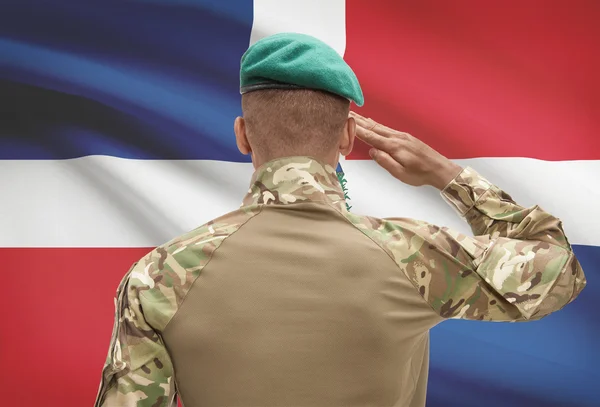 Dark-skinned soldier with flag on background - Dominican Republic — Stock Photo, Image