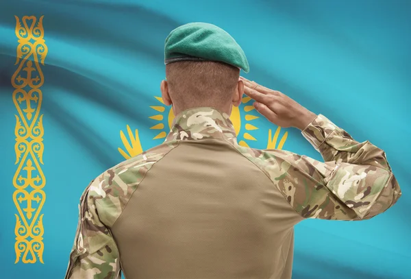 Dark-skinned soldier with flag on background - Kazakhstan — Stock Photo, Image