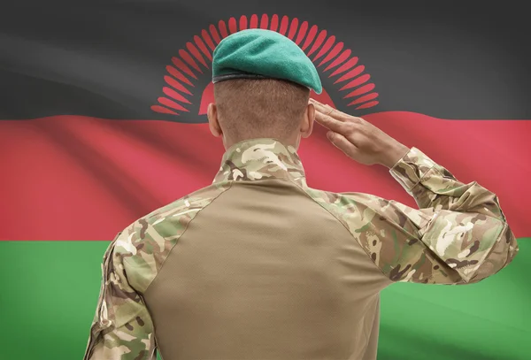 Dark-skinned soldier with flag on background - Malawi — Stock Photo, Image