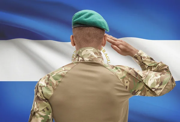 Donkerhuidige soldaat met vlag op achtergrond - Nicaragua — Stockfoto
