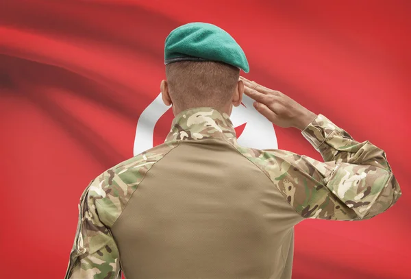 Dark-skinned soldier with flag on background - Tunisia — Stock Photo, Image