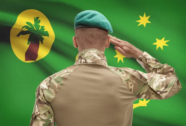 Dark-skinned soldier with flag on background - Cocos (Keeling) Islands — Stock Photo, Image