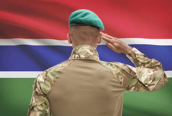 Piel oscura soldado con bandera sobre fondo - Gambia —  Fotos de Stock