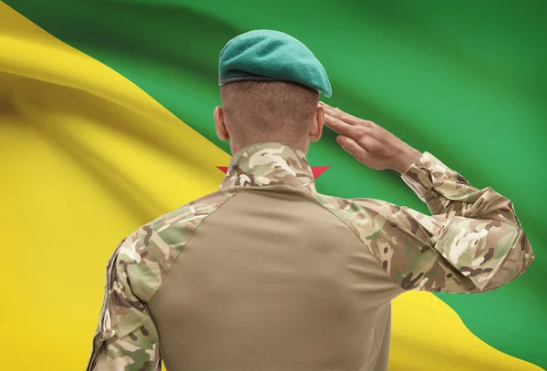 Dark-skinned soldier with flag on background - French Guiana — Stock Photo, Image