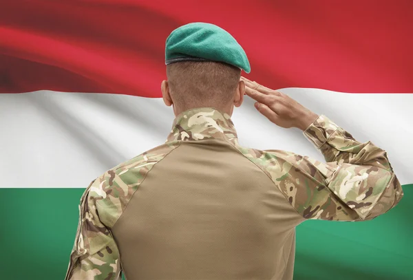 Dark-skinned soldier with flag on background - Hungary — Stock Photo, Image