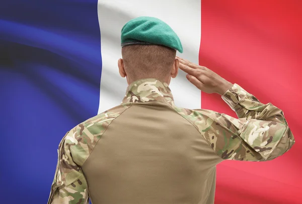 Dark-skinned soldier with flag on background - France — Stock Photo, Image
