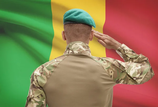 Dark-skinned soldier with flag on background - Mali — Stock Photo, Image